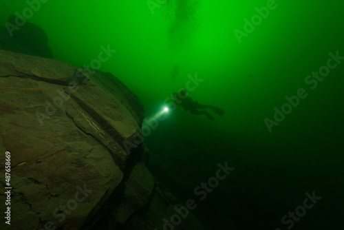 Taucher betaucht eine Felswand im Zugersee in der Schweiz photo