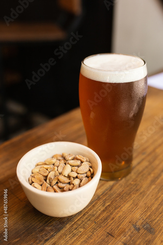 Fototapeta Naklejka Na Ścianę i Meble -  craft beer next to salted peanuts