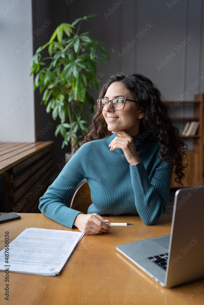 Confident lecturer woman relaxed look in window after online class, lecture or training. Successful businesswoman in eyeglasses sit at office desk with laptop and business papers happy and satisfied Confident lecturer woman relaxed look in window after online class, lecture or training. Successful businesswoman in eyeglasses sit at office desk with laptop and business papers happy and satisfied