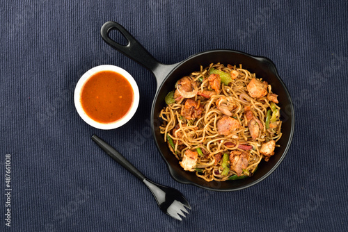 chicken noodles served with sauce on blue kitchen cloth