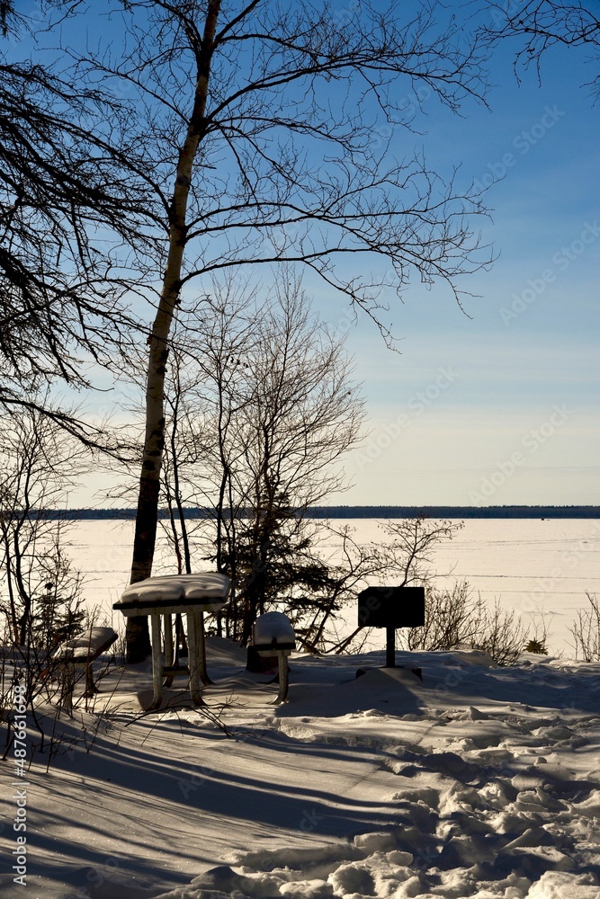 a winter picnic site on the shore of a snow covered lake