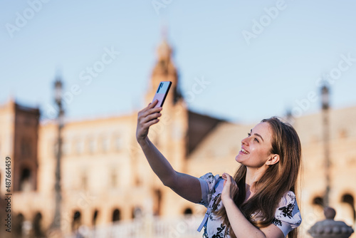 Young happy woman making a video call with her smartphone from Europe