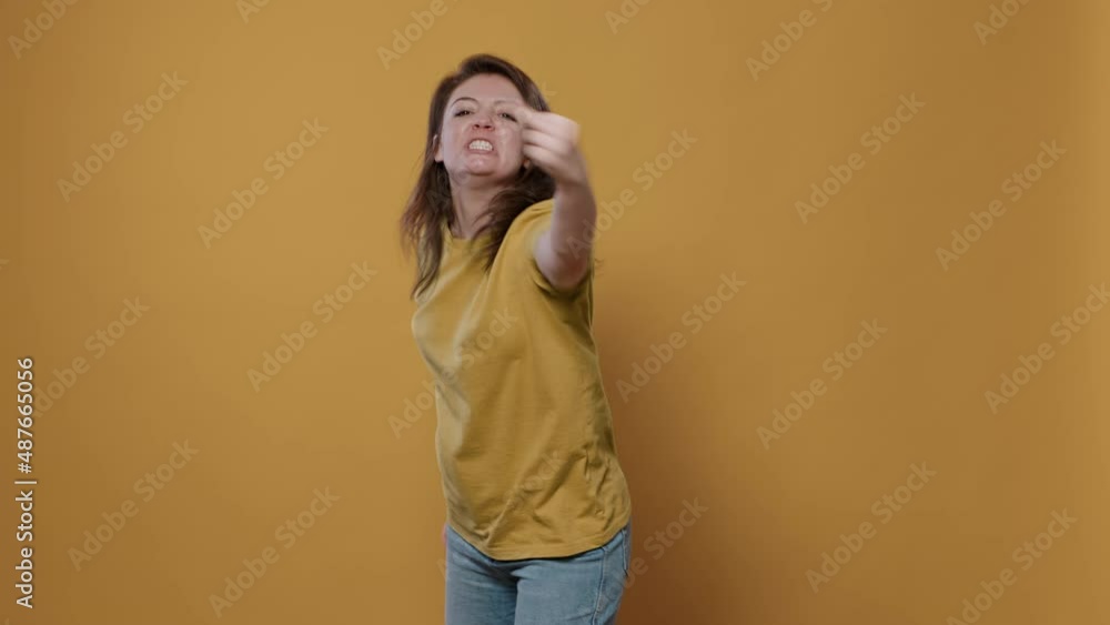 Angry woman having aggressive attitude problem being rude and disrespectful in studio. Unhappy person showing middle finger obscene hand gesture showing aggresion and anger. Angry woman having aggressive attitude problem being rude and disrespectful in studio. Unhappy person showing middle finger obscene hand gesture showing aggresion and anger.