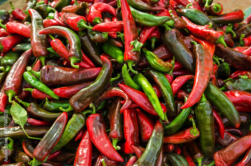 Leinwand Poster Harvest of red hot pepper lies on a pile