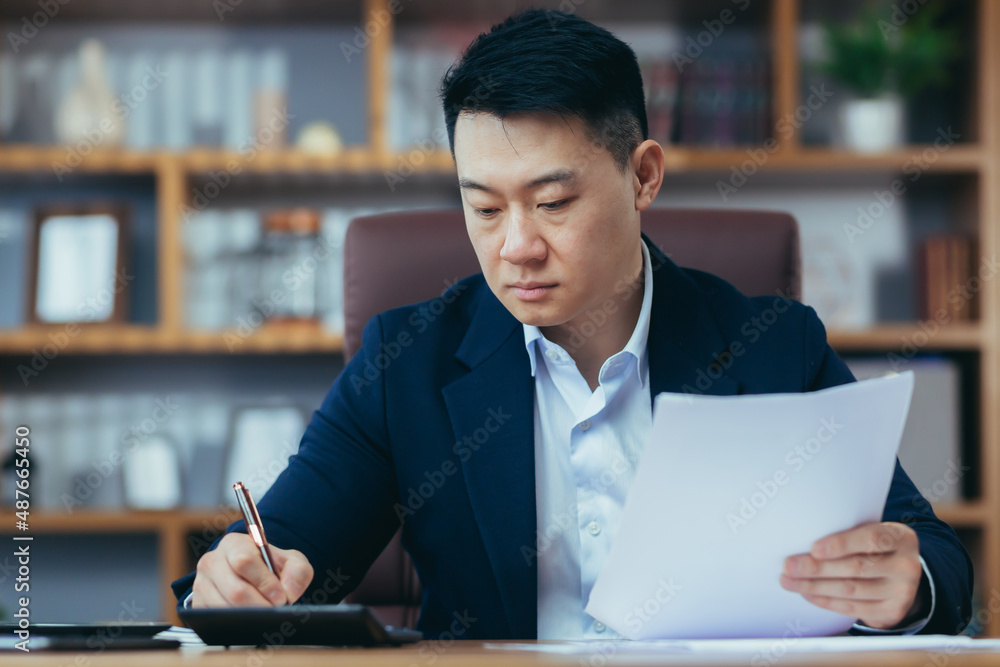 Close-up photo of businessman in office working on paper, serious and focused asian boss signing documents Close-up photo of businessman in office working on paper, serious and focused asian boss signing documents