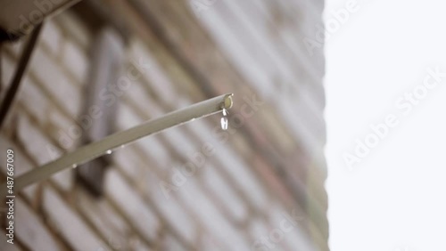 Drops of water falling from the hose from the air conditioner. Plastic drain pipe from air conditioning outside building. Air conditioning