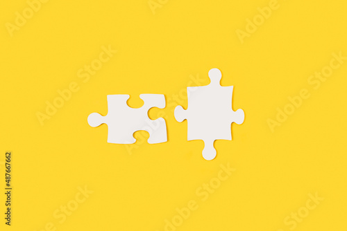 Piezas de rompecabezas en blanco sobre un fondo amarillo liso y aislado. Vista superior. Copy space. Concepto: Negocios