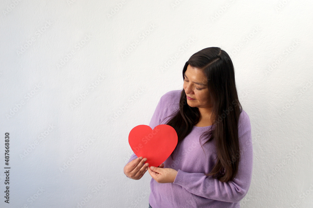 Latin adult woman with red heart shows her sadness, anger and unhappiness for the arrival of February and celebrating Valentine's Day of Love and Friendship
Latin adult woman with red heart shows her sadness, anger and unhappiness for the arrival of February and celebrating Valentine's Day of Love and Friendship