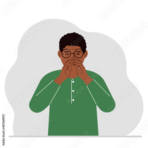 The man covers his nose with his hands. The concept of a sick person, sneezes, seasonal allergies, bad smell.