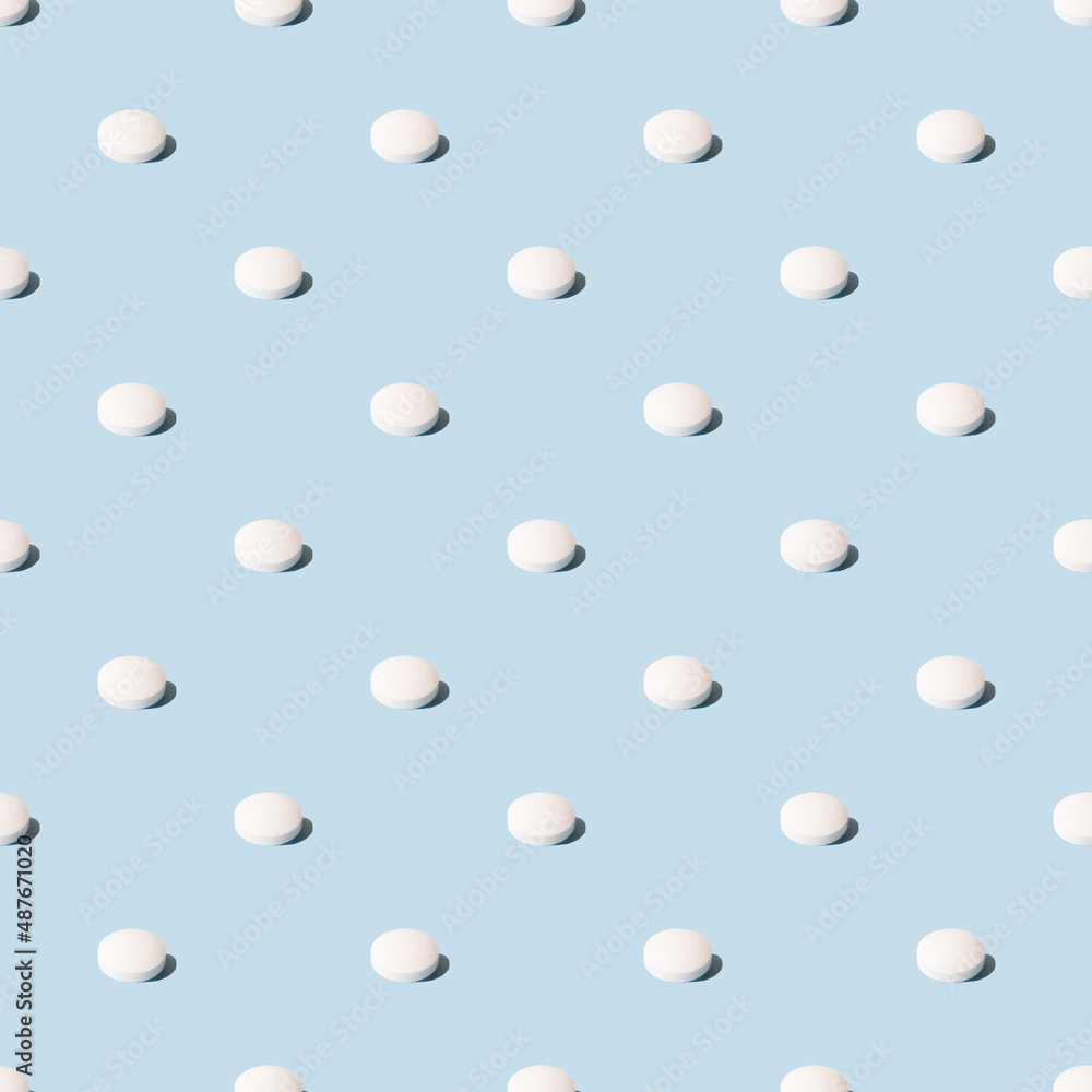 White pills on a blue background. Seamless pattern for the background. Medical pharmacy flat lay design for presentation packaging website flyer cover business cards.