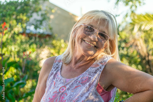 mujer rubia sonriendo en un espacio verde y soleado  photo