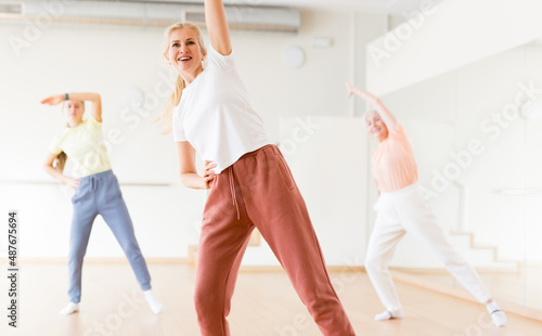 Woman dancing modern dance with other women during group training