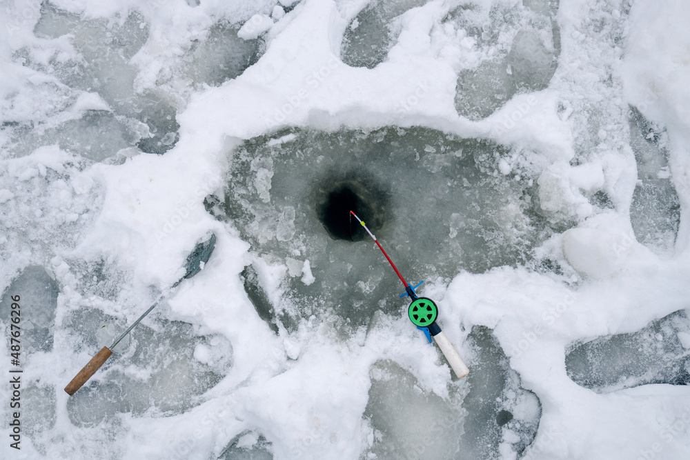 ice fishing. winter fishing. The fishing rod lies in the snow ice fishing. winter fishing. The fishing rod lies in the snow