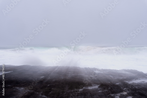 landscape of a wave crashes against the reef