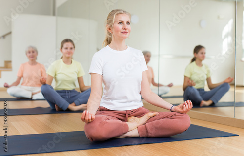 Closeup of positive woman practice yoga lotus pose to meditation in modern studio