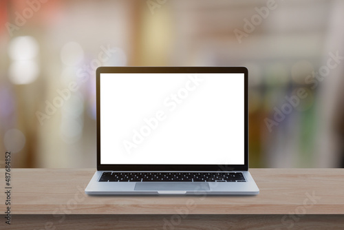 Modern Laptop computer with blank screen on wood table over blur bokeh light background.