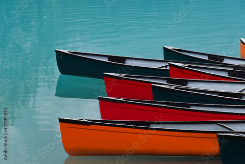 Colorful canoes lined up on turquoise lake
