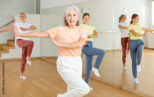 Ordinary active females exercising dance moves in dance center