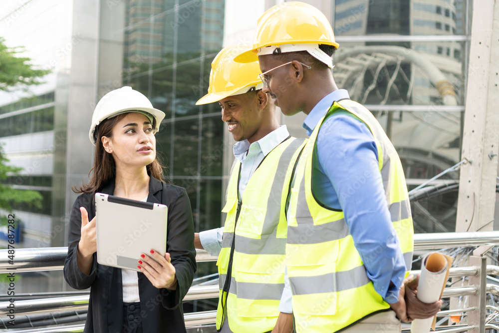 Group of Engineer Worker Wearing Safety Uniform and Hard Hat Uses Tablet Computer. Happy Successful. Businesswomen working with tablet checklist Group of Engineer Worker Wearing Safety Uniform and Hard Hat Uses Tablet Computer. Happy Successful. Businesswomen working with tablet checklist