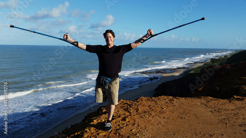 People with physical disabilities. Disabled man with open arms on the beach.