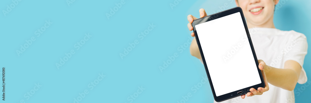 Happy smiling boy showing smartphone mockup in a blue backdrop. mobile phone , tablet screen mockup