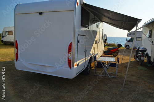 caravans cars by the sea in summer holidays, tent table motorbikes