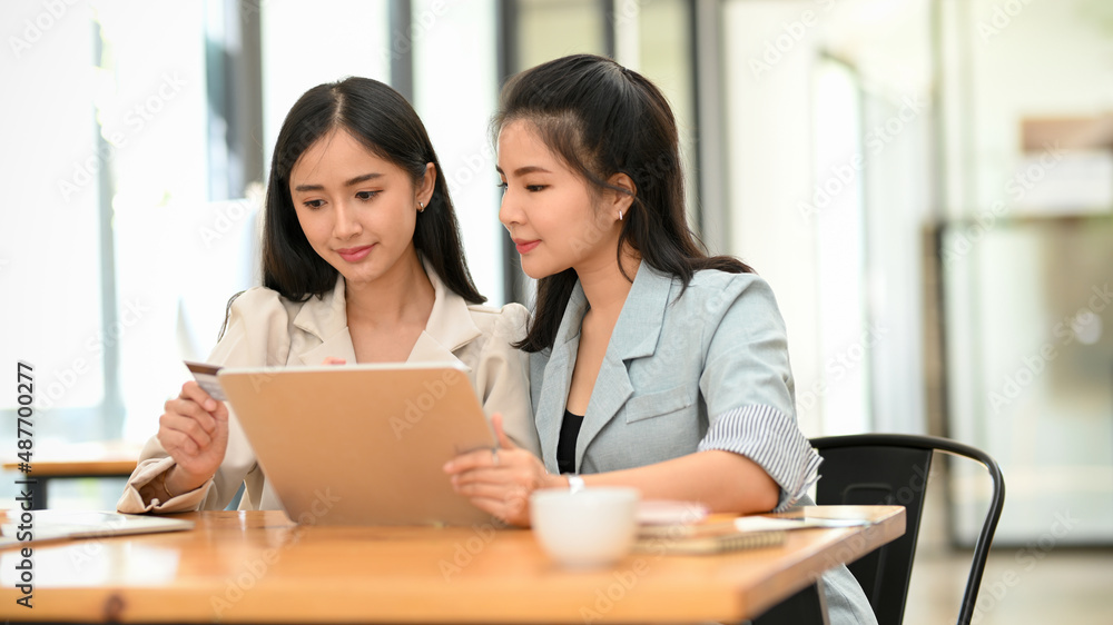 Businesswomen are working together on digital tablet computer. Businesswomen are working together on digital tablet computer.