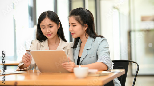 Businesswomen are working together on digital tablet computer.