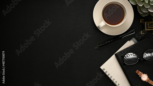 Minimal black workspace background with accessories and copy space.