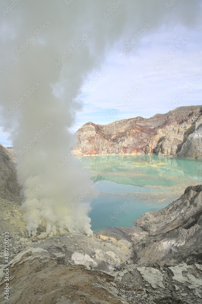 dangerous sulfur smoke cloud, turquoise lake in the back Kawah Ijen, Java, Indonesia