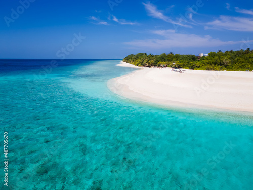 White sand beach on tropical island with turquoise sea water and blue sky, perfect holidays vacation destination. Luxury travel, honeymoon. Pristine scenic coastline with coral reef.