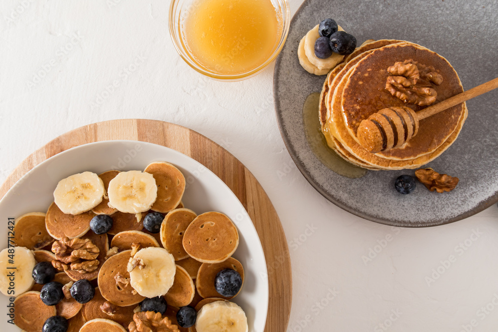 tiny pancakes - cute healthy breakfast - a new concept food trend. a great snack with fruits, berries, honey, milk. top view. tiny pancakes - cute healthy breakfast - a new concept food trend. a great snack with fruits, berries, honey, milk. top view.