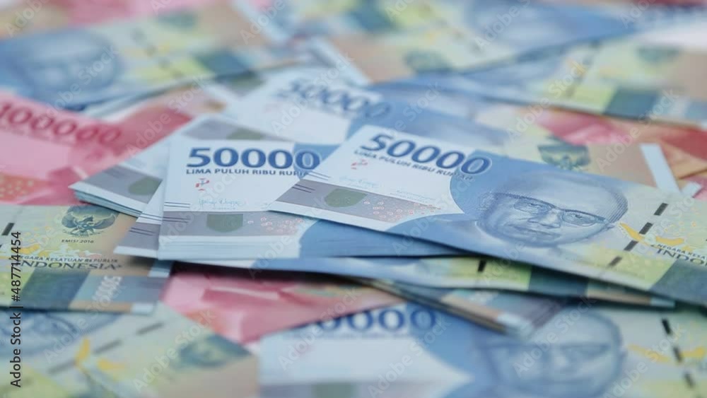 Close up Dropping stacks of Indonesian money Close up Dropping stacks of Indonesian money