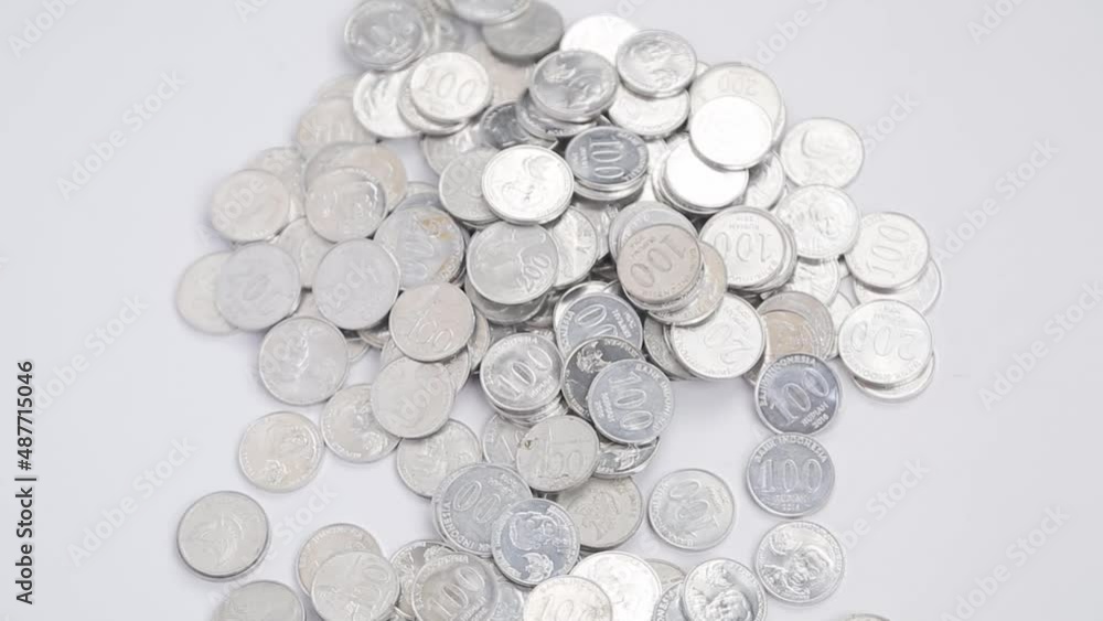 hand scooping a piles of indonesian coin hand scooping a piles of indonesian coin