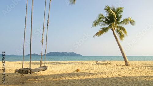 Pretty woman swinging on a swing on a tropical beach, on shores of the turquoise sea. Concept travel, walks, rest in sea, tropical resort coastline relaxation traveling tourism summer holidays