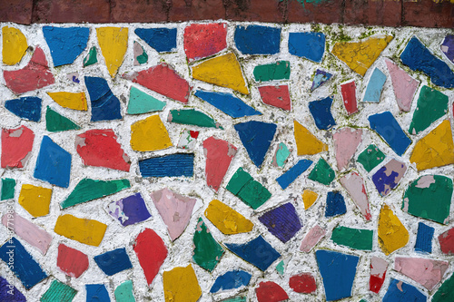 Multicolored mosaic on the exterior wall. Multicolored geometric shapes in a white wall. Abstract background