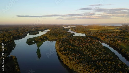 Aerial view overlooking islands on the Tornionjoki river, golden hour in Lapland - tracking, drone shot photo