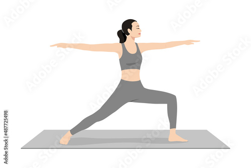 Warrior Pose II. Beautiful girl practice Virabhadrasana I. Young attractive woman practicing yoga exercise. working out, black wearing sportswear, grey pants and top, indoor full length, calmness photo