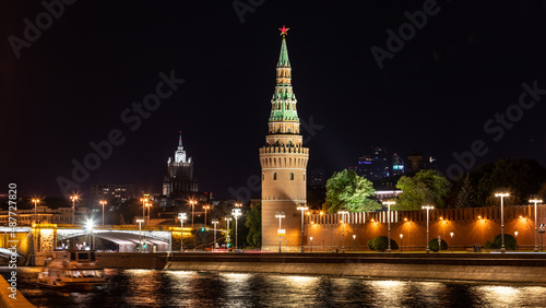 Stadtansicht Moskaus mit der Moskwa sowie Brücke im Vordergrund und dem beleuchteten Kreml samt Mauer, Türmen sowie anderen Gebäuden bei Nacht photo