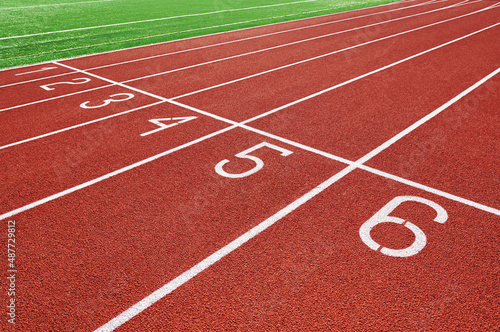 Red runninng race track with lane numbers closeup, Treadmill at stadium, Summer sport and fitness concept © Lazy_Bear