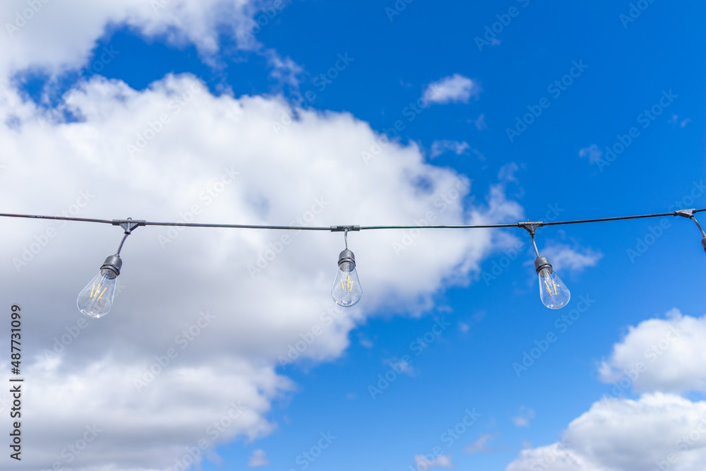 Several LED bulbs on sky background. Saving energy concept. White energy-saving light bulbs. Light bulbs lie in a row. Several LED bulbs on sky background. Saving energy concept. White energy-saving light bulbs. Light bulbs lie in a row.