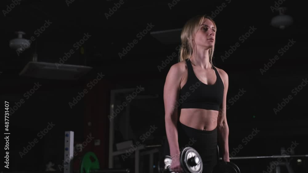 Woman exercising her arms with dumbbells Woman exercising her arms with dumbbells