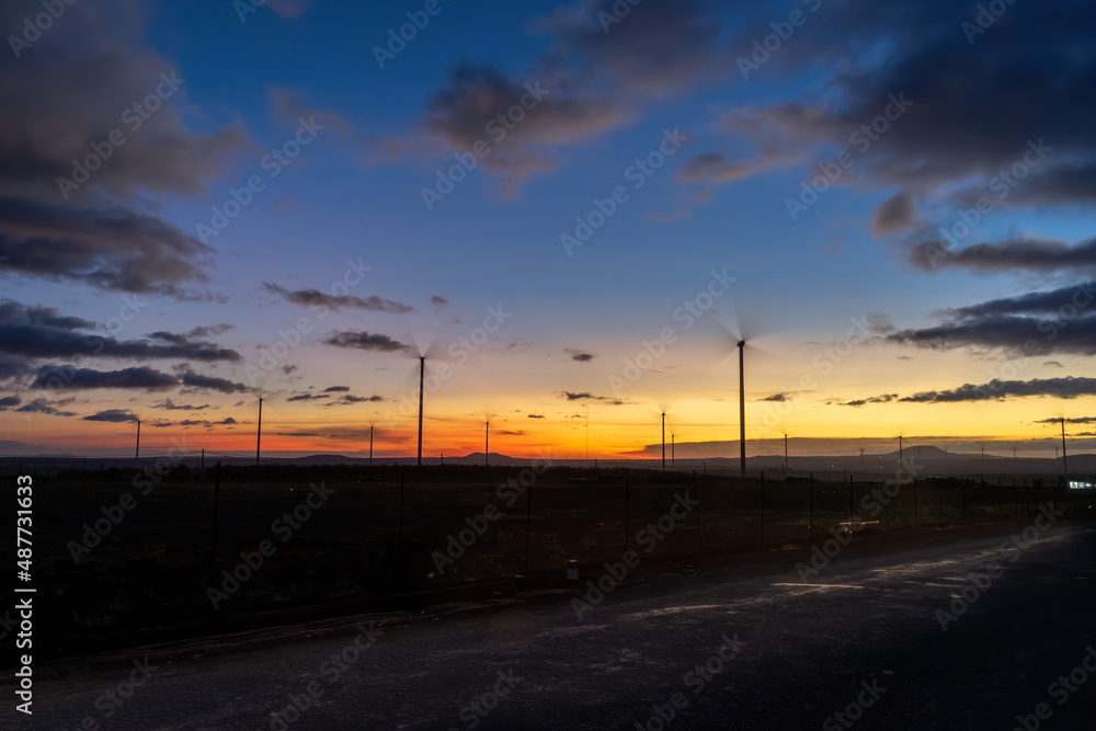 Wind turbine farm and agricultural fields on a summer day. Wind electricity generator in sunset sky, power plant, wind efficiency. Wind turbine farm and agricultural fields on a summer day. Wind electricity generator in sunset sky, power plant, wind efficiency.