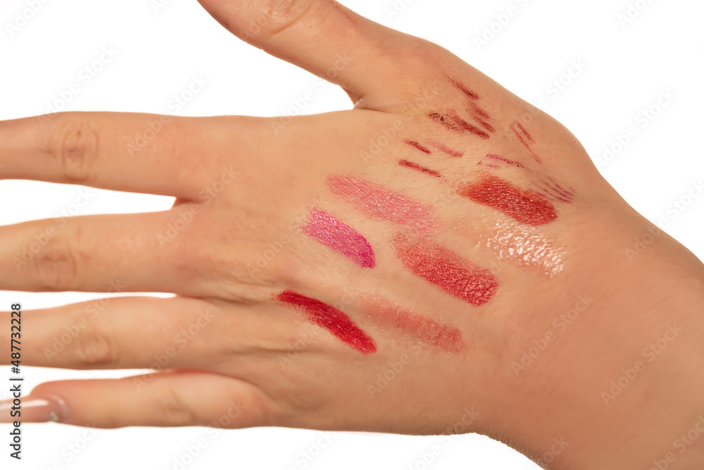 Samples of lipstick and lip pencils on the hand of a woman Samples of lipstick and lip pencils on the hand of a woman