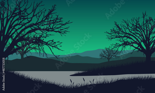 Scenic view of mountains in the countryside with the silhouette of dry pine trees and river around