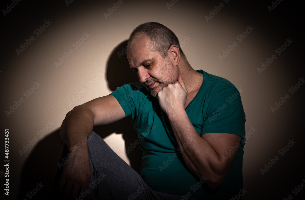 Mid age man suffering from anxiety, depression due to social seclusion, isolation, consequence of covid-19 Mid age man suffering from anxiety, depression due to social seclusion, isolation, consequence of covid-19