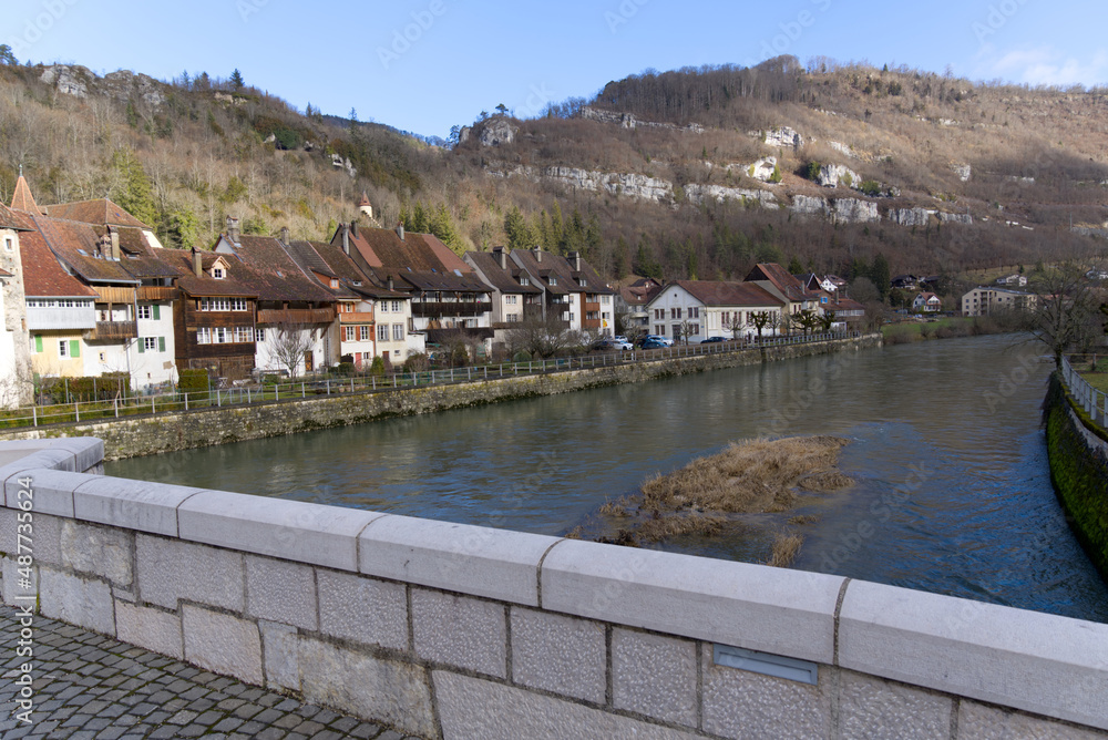 View from chalk stone bridge over the river Doubs at little medieval town St-Ursanne, Canton Jura, on a sunny winter morning. Photo taken February 7th, 2022, Saint-Ursanne, Switzerland. View from chalk stone bridge over the river Doubs at little medieval town St-Ursanne, Canton Jura, on a sunny winter morning. Photo taken February 7th, 2022, Saint-Ursanne, Switzerland.