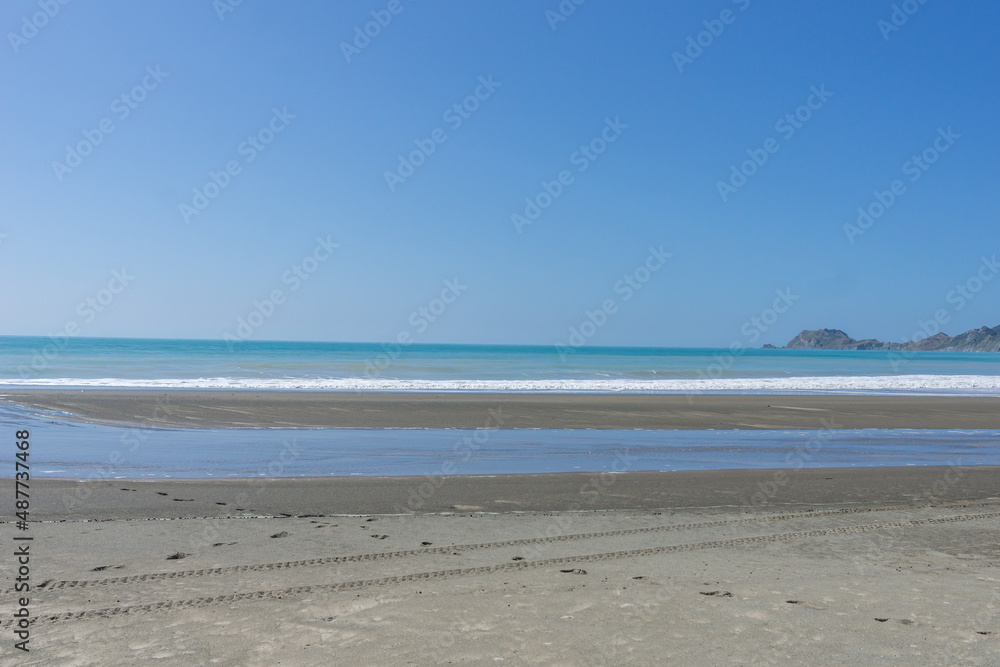Tokomaru Bay beach with surf waves crashing onto beach Tokomaru Bay beach with surf waves crashing onto beach
