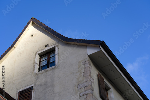 Window with wooden shutters at little medieval town St-Ursanne, Canton Jura, on a sunny winter morning. Photo taken February 7th, 2022, Saint-Ursanne, Switzerland.