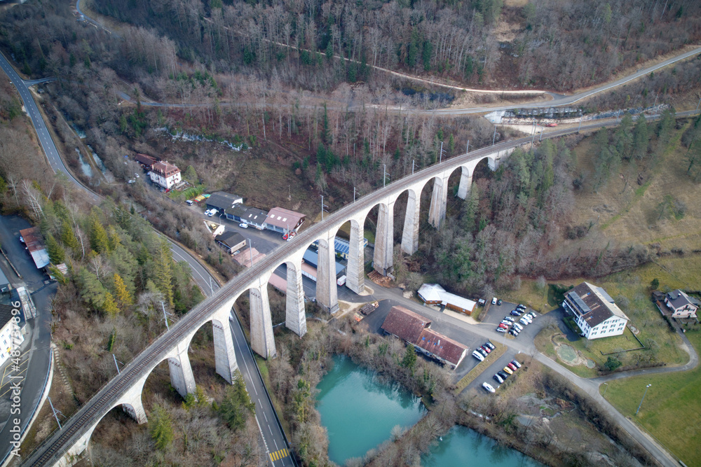 Aerial view of beautiful landscape at medieval Village St-Ursanne, Canton Jura, with railway viaduct. Photo taken February 7th, 2022, Saint-Ursanne, Switzerland.
